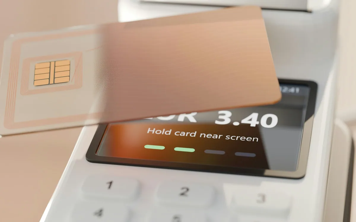 Tarjeta bancaria acercandose a un terminal de pago digital