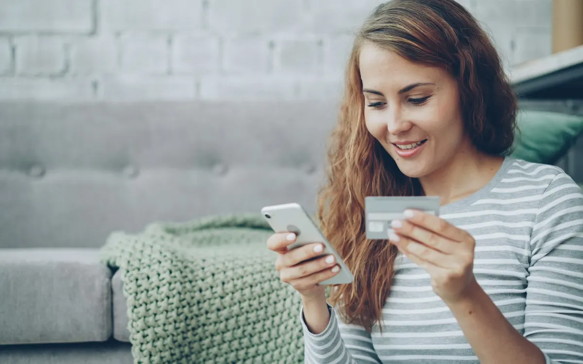 Mujer compra por internet usando una tarjeta y su teléfono